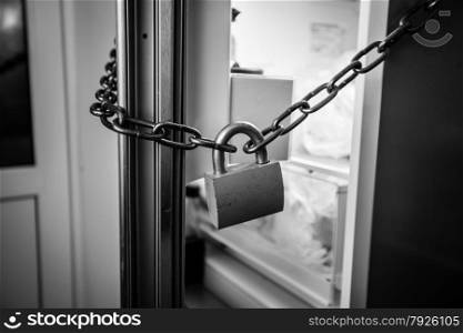 Black and white photo of fridge locked by chain