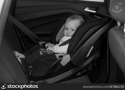 Black and white photo of little baby on back seat