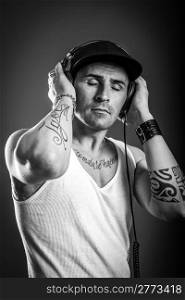 black and white photo of man with tatoos who is listening to music