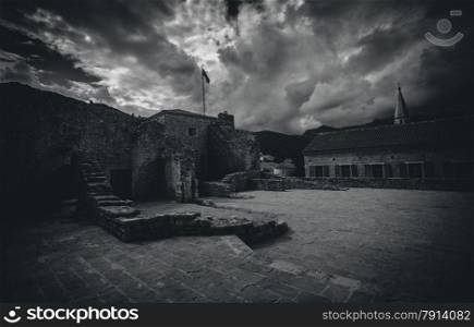 Black and white photo of old ruined castle at cloudy day