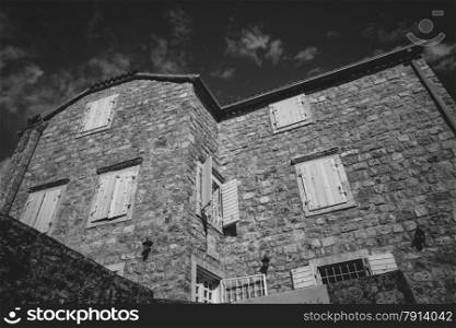 Black and white photo of old stone house at sunny day