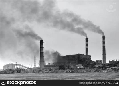 Black and white photo of plant with smoke. Air pollution