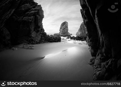 Black and white photo of rocky coastline of Atlantic ocean, Ursa beach, Portugal