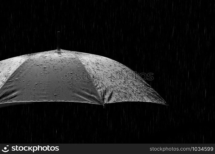 Black and white photo of umbrella in heavy rain