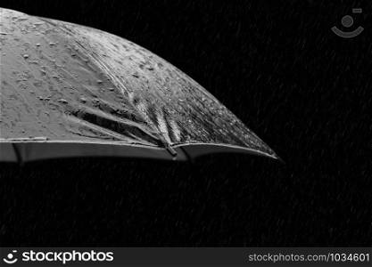 Black and white photo of umbrella in heavy rain