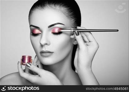 Black and white photo of woman applies eye shadow. Perfect makeup. Makeup detail. Beauty girl with perfect skin. Nails and manicure
