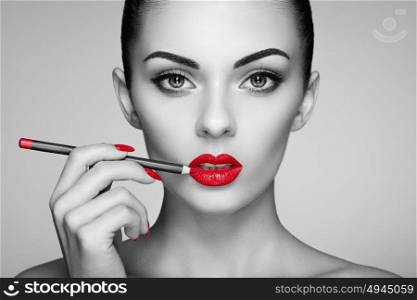 Black and white photo of woman painting lipstick. Beautiful woman face. Makeup detail. Beauty girl with perfect skin. Red lips and nails manicure