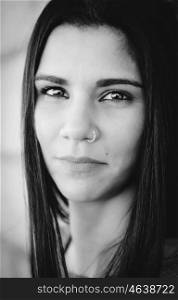 Black and white portrait girl with a piercing in her nose looking at camera