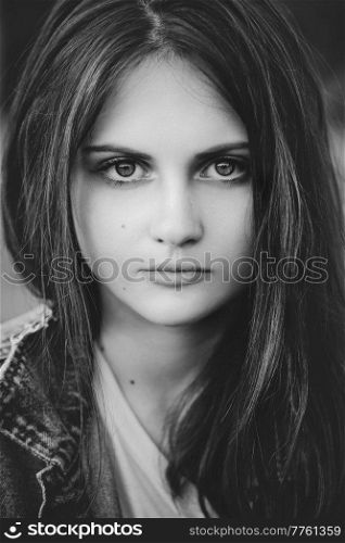 black and white portrait of a teenage girl with long hair on a nature background. Portrait of a teenage girl with long hair
