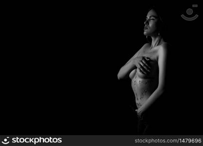 black and white portrait of a young girl with the words humiliation, bullying, hate,freedom,gender inequality on her naked body. the captions are written in the photographer&rsquo;s hand, not in a tattoo .