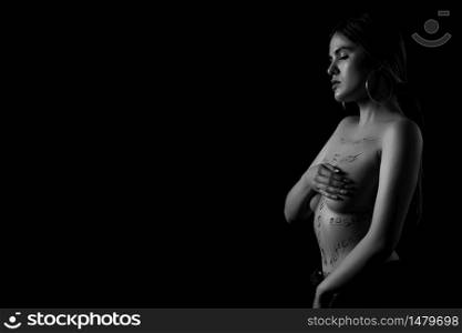 black and white portrait of a young girl with the words humiliation, bullying, hate,freedom,gender inequality on her naked body. the captions are written in the photographer&rsquo;s hand, not in a tattoo .