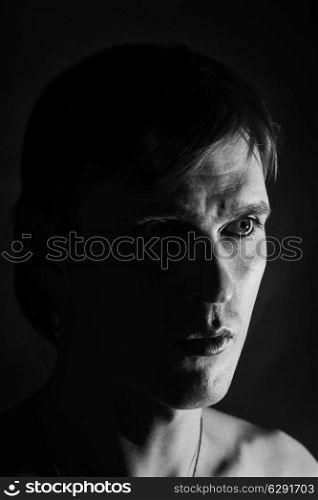 Black and white portrait of a young man on a black background