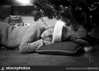 Black and white portrait of cute girl sleeping under Christmas tree