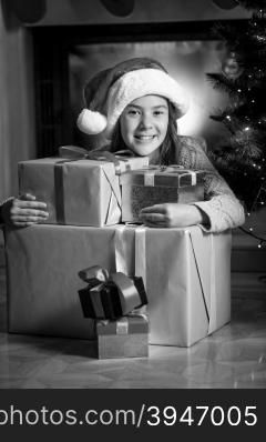 Black and white portrait of cute smiling girl posing with Christmas gift boxes