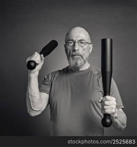 black and white portrait of senior man (in late 60s) exercising with heavy steel clubs, fitness over 60 concept