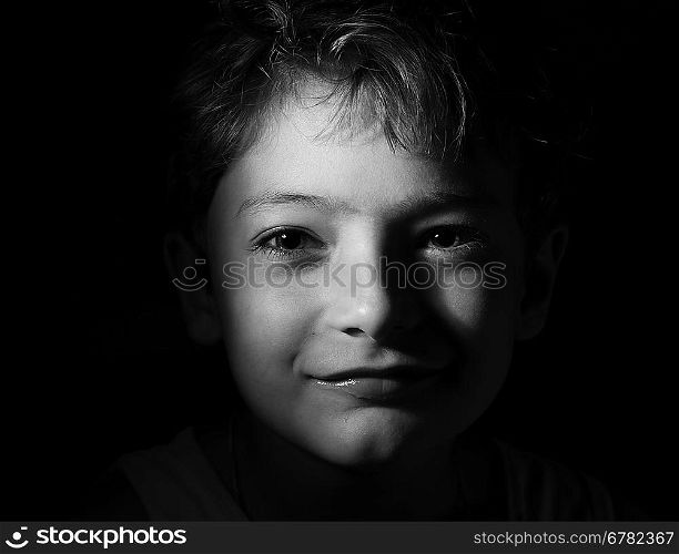 black and white shot of the boy in the dark, focused light on the head