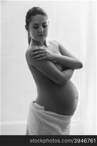 Black and white silhouette of beautiful pregnant woman posing in shower
