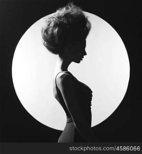 Black and white studio photo of elegant woman on geometric background