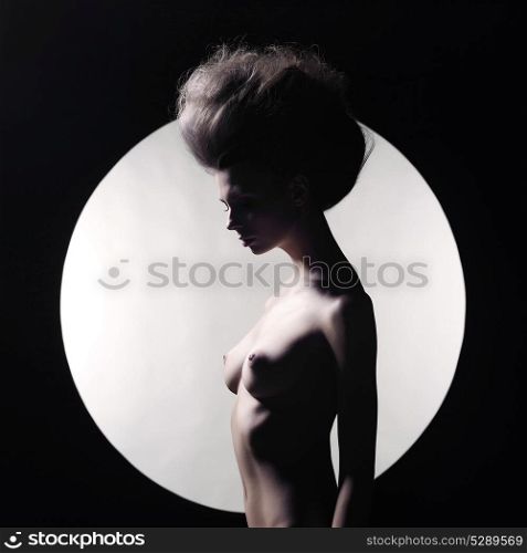 Black and white studio photo of nude elegant woman on geometric background