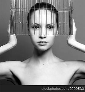 Black and white surrealistic portrait of young lady with cage