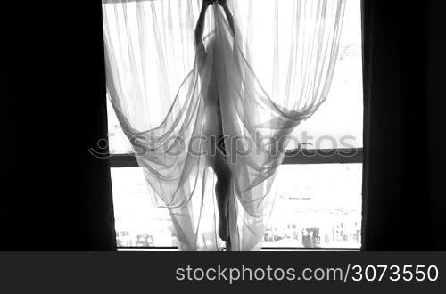 Black and white video of sexy beautiful girl wearing lingerie in the window
