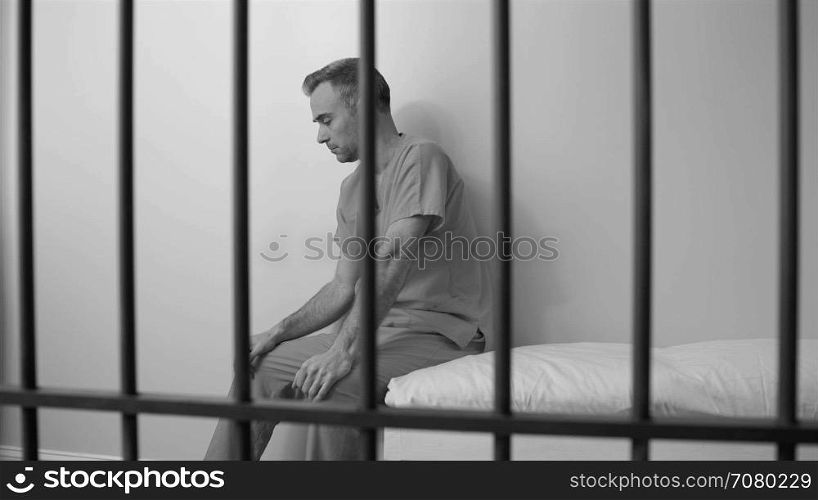 Black and white view of inmate regrets his life choices in prison
