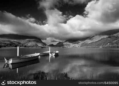 Black and white View of rowing boats on Llyn Nantlle in Snowdonia landscape at sunset