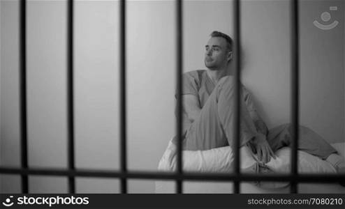 Black and white view of Sad inmate reflecting on life in prison