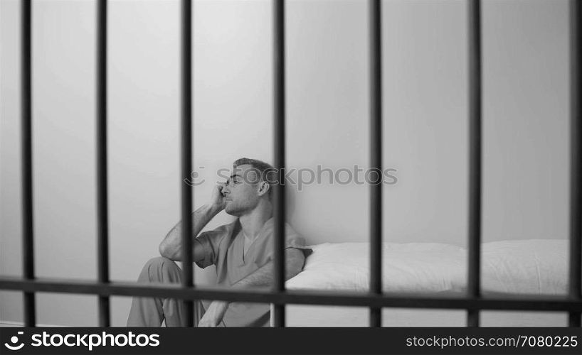 Black and white view of scene of a morose inmate in prison