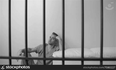 Black and white view of scene of a thoughtful inmate in prison