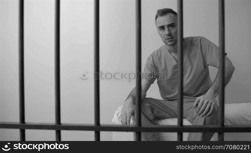 Black and white view of scene of an emotional inmate in prison