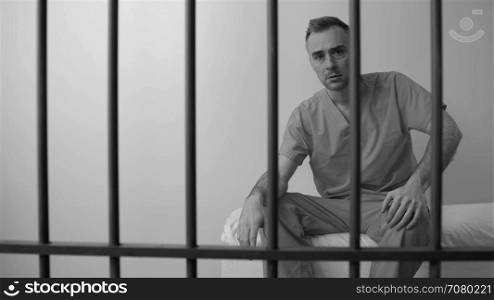 Black and white view of scene of an emotional inmate in prison