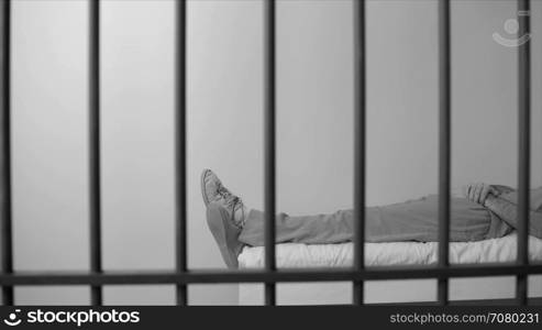 Black and white view of scene of an inmate sleeping in prison