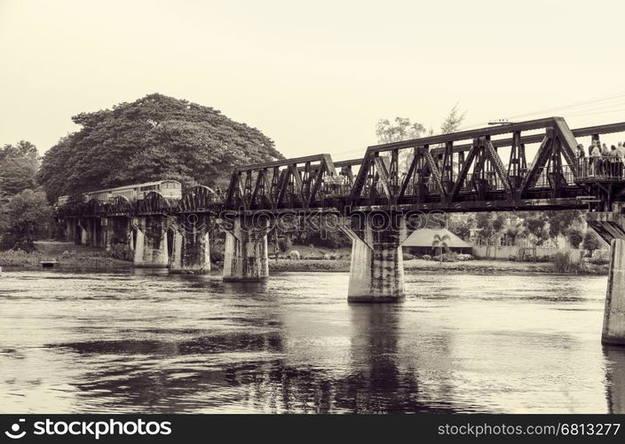 Black and white vintage photo style trains for travel running on the old bridge over the River Kwai is a historical attractions during World War 2 the famous of Kanchanaburi Province in Thailand