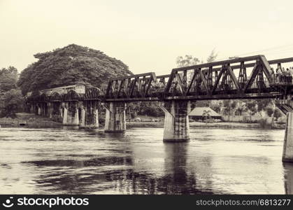Black and white vintage photo style trains for travel running on the old bridge over the River Kwai is a historical attractions during World War 2 the famous of Kanchanaburi Province in Thailand