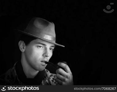 Black and white vintage portrait of a man in a hat smoking his pipe. Space for copy on a black background.. Black And White Vintage Portrait Of A Man With Pipe