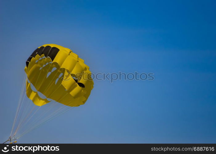 Black and yellow parachute . Black and yellow parachute on a blue sky background