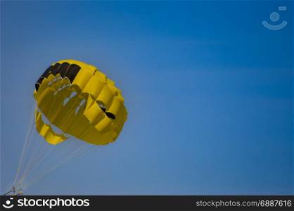 Black and yellow parachute . Black and yellow parachute on a blue sky background