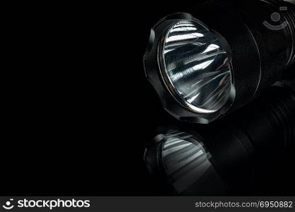 black anodized aluminium waterproof tactical flashlight on black background