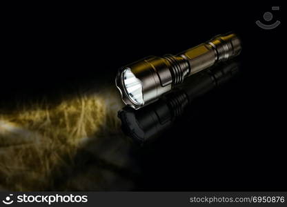 black anodized aluminium waterproof tactical flashlight on dark background