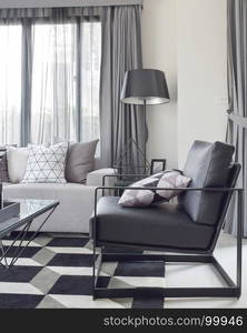 Black armchair with geometric rug in modern living corner