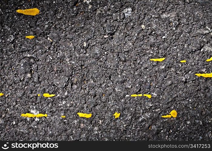Black asphalt with yellow paint spots texture