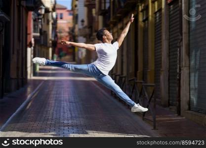 Black athletic man doing an acrobatic jump outdoors. Cuban male.. Black athletic man doing an acrobatic jump outdoors