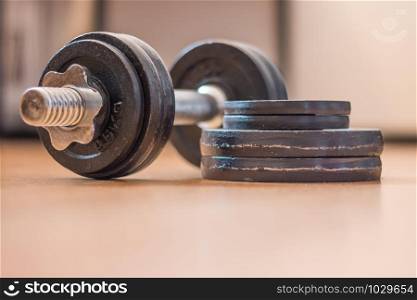 Black bar bell on the wooden floor, physical exercise