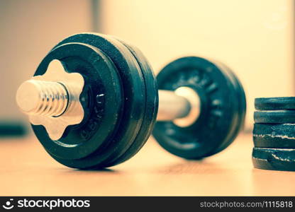 Black bar bell on the wooden floor, physical exercise