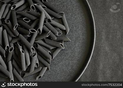 Black bean penne pasta on black plate