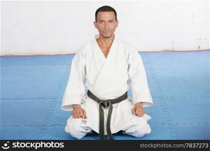 Black Belt karate man sit on a position to start or finish practicing