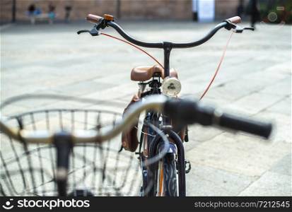 Black bike mounted on a bicycle stand on italian street.
