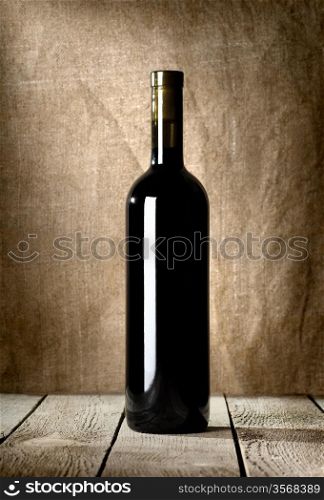 Black bottle of wine on the background of the canvas