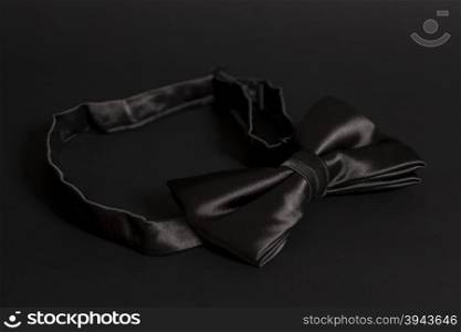 Black bow tie on black background